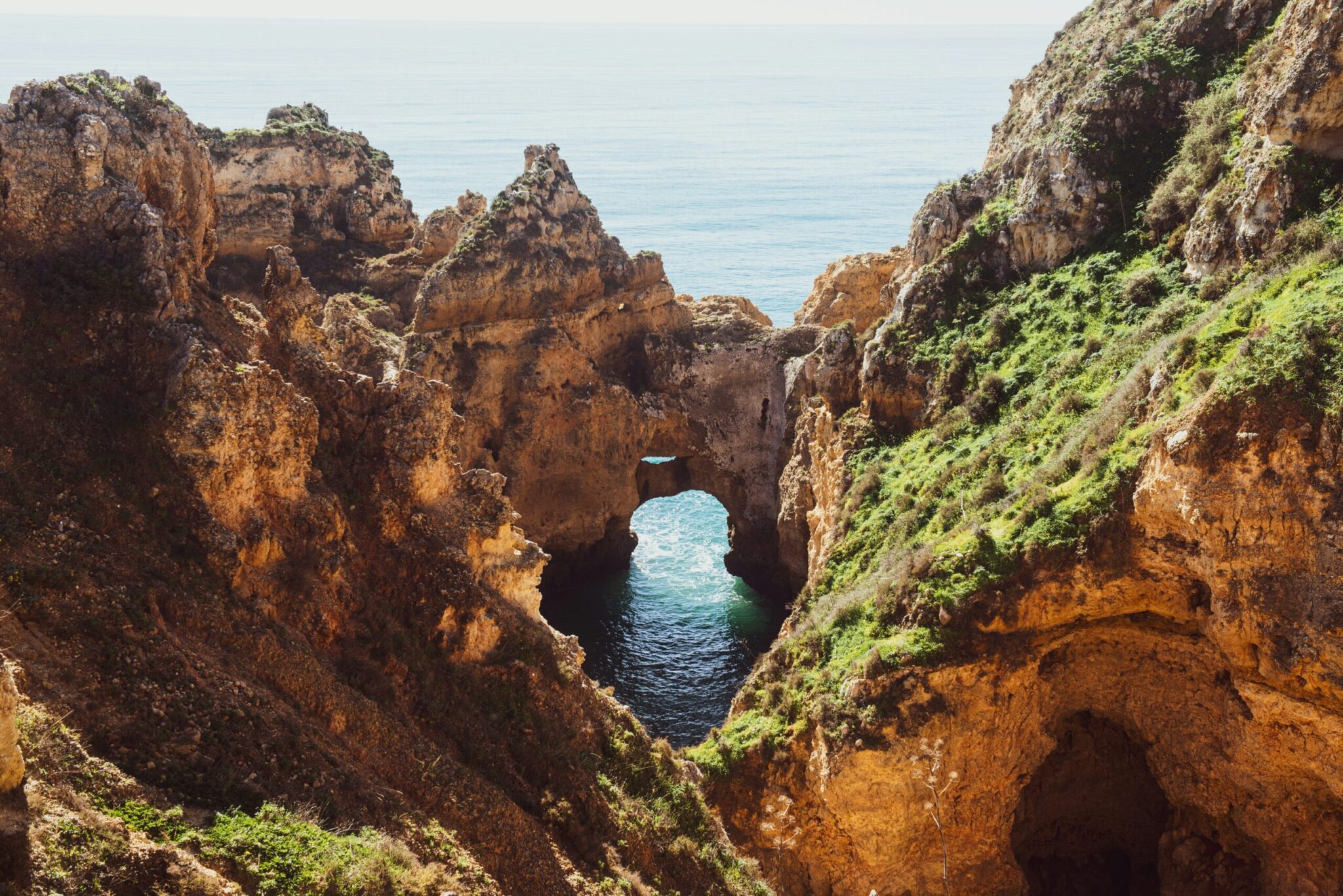 Natural limestone arch and clear Atlantic water on the Algarve coast in Portugal