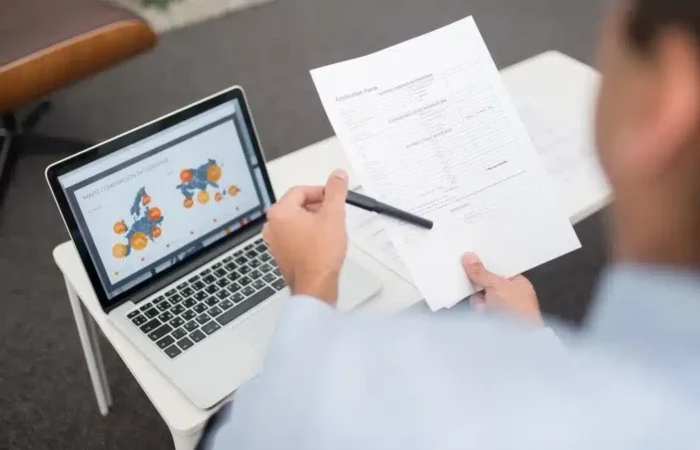 A person reviewing an application form beside a laptop — Portugal student visa bank statements