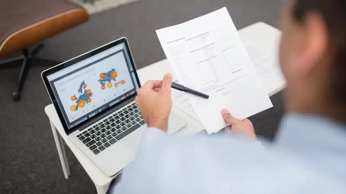 A person reviewing an application form beside a laptop — Portugal student visa bank statements