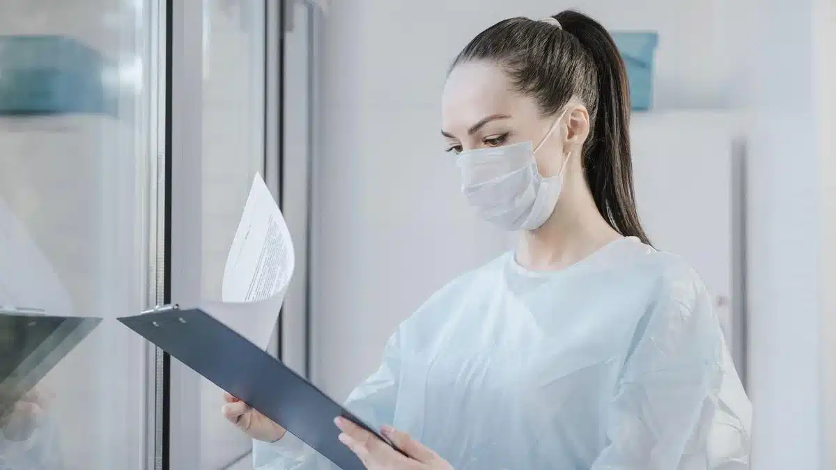 Healthcare professional reviewing medical records on a clipboard — Portugal Student Visa Health Insurance