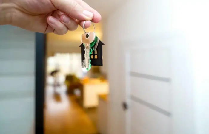 A hand holding house keys inside a modern apartment — Portugal Student Visa Accommodation Proof