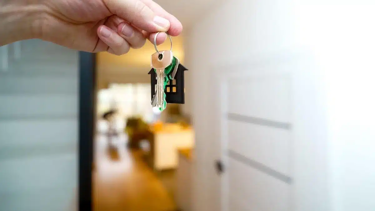 A hand holding house keys inside a modern apartment — Portugal Student Visa Accommodation Proof