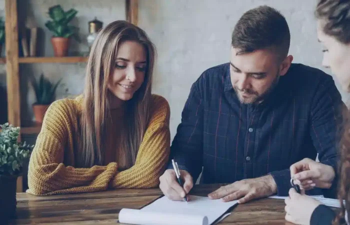 Young professionals reviewing and signing a contract in an office — work after studying in Portugal