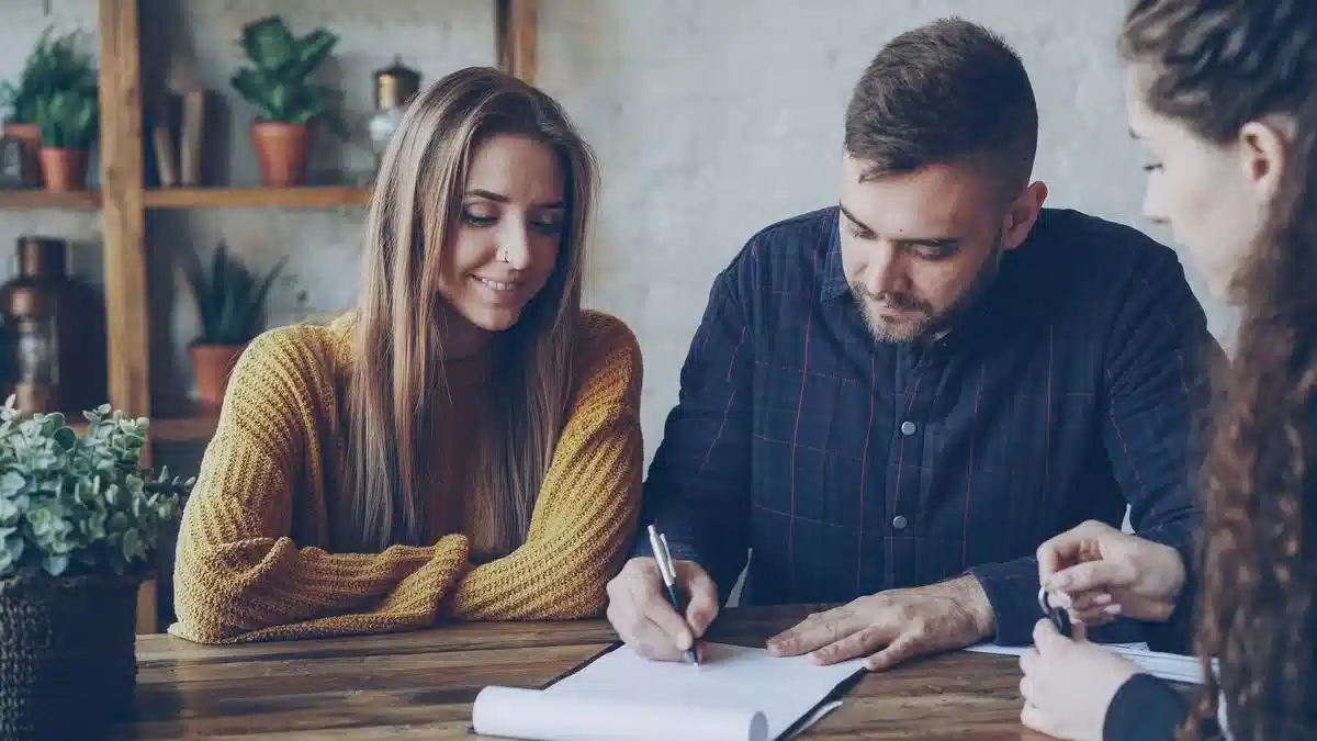 Young professionals reviewing and signing a contract in an office — work after studying in Portugal