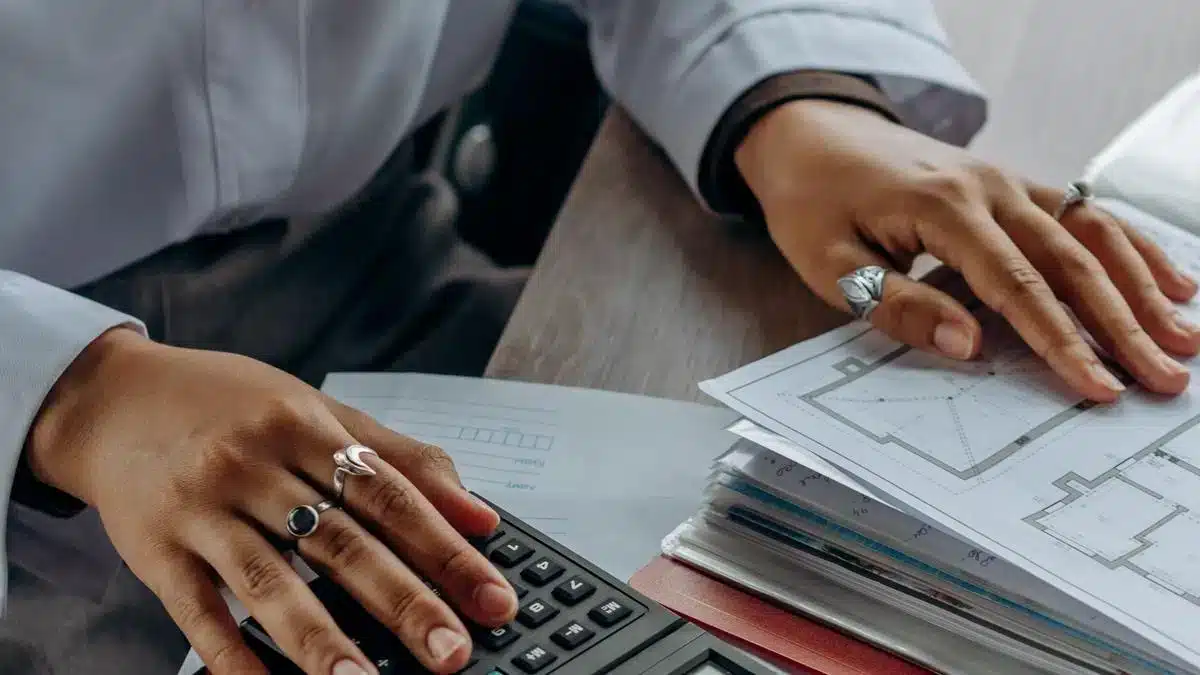A professional reviewing financial documents with a calculator at a desk — Portugal Startup Visa financial requirements
