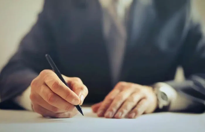 A businessman signing a formal contract at an office desk — Portugal Startup Visa company before applying