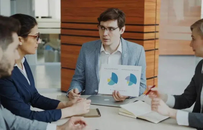 A business team evaluating charts during a formal meeting — Portugal Startup Visa evaluation criteria