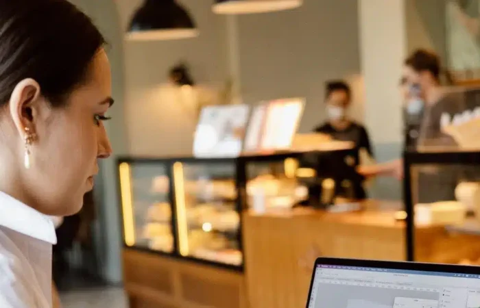 A remote worker using a laptop in a modern coffee shop — Portugal digital nomad temporary stay vs residence visa