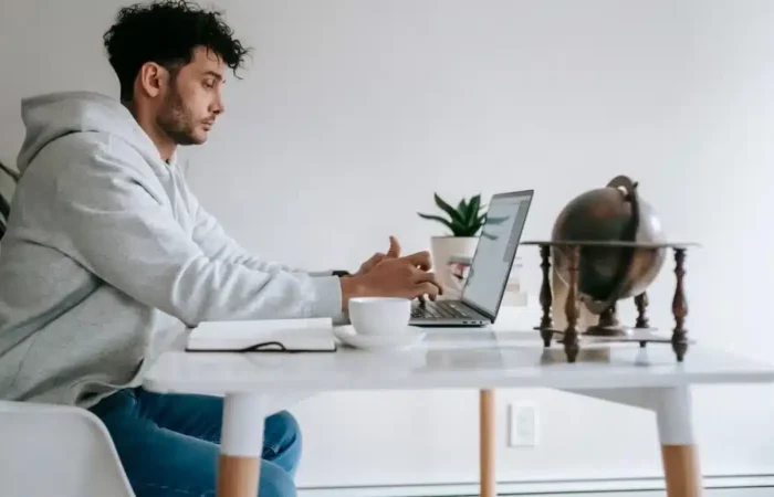 A remote employee working on a laptop at a home-office desk — Portugal digital nomad visa employee