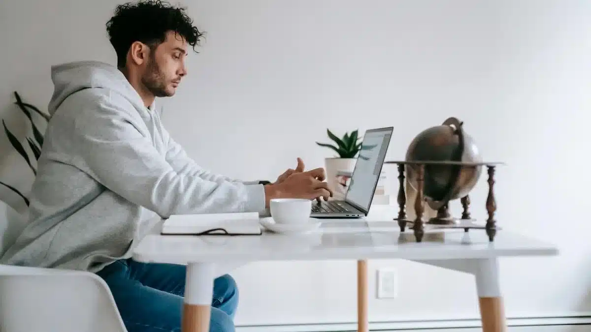 A remote employee working on a laptop at a home-office desk — Portugal digital nomad visa employee