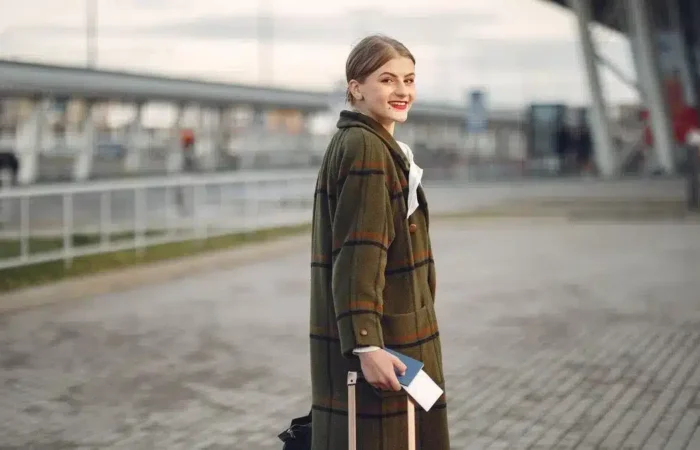 A traveler walking with luggage and a passport at a transportation terminal — after Portugal digital nomad visa AIMA residence permit