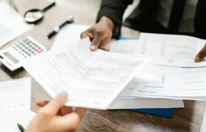 Two professionals exchanging official paperwork across an office desk — how to get NISS Portugal foreigner